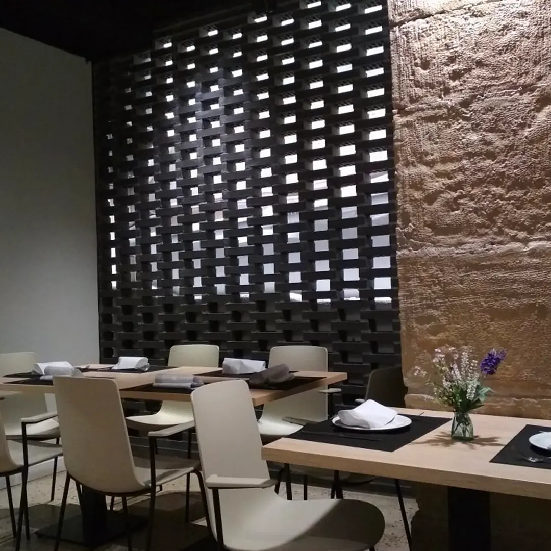 Comedor con mesas y pared de piedra